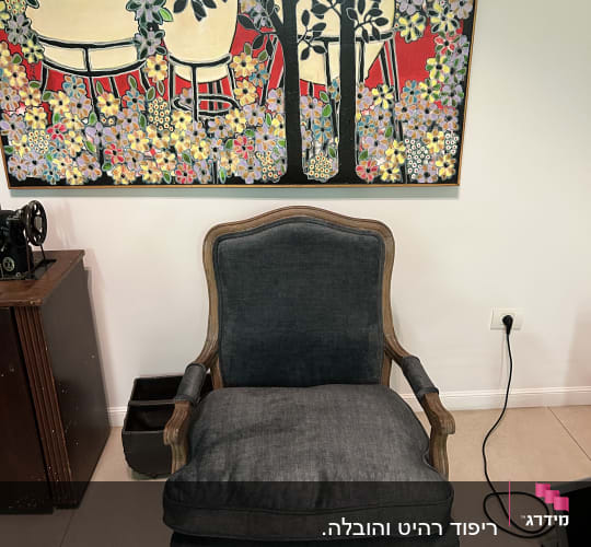 כורסה מרופדת בבד כהה עם כרית ישיבה גדולה